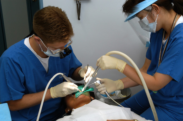 Us Navy 030620 N 8937 A 002 Lt. William Peterson (Left) Of Branch Dental Clinic Sasebo, Japan Drills A Cavity While His Dental Assistant, Miho Otubo, Ensures The Area Remains Clean